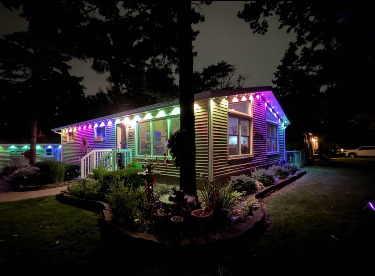 Ranch home at night with permanent multicolor lighting along the front roofline